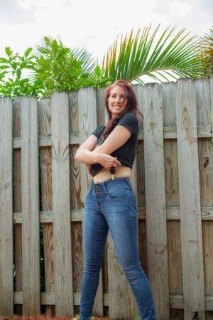 Hot redhead Andy Adams loses her t-shirt & jeans in the yard to pose naked on picsofsex.com