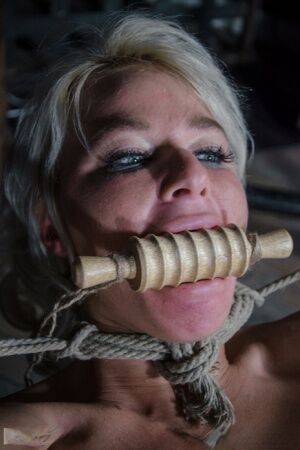 Platinum blonde London River is gagged and tied up in a dungeon on picsofsex.com