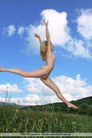 Flexible blonde teen Thea C juggles while completely naked in a field on picsofsex.com