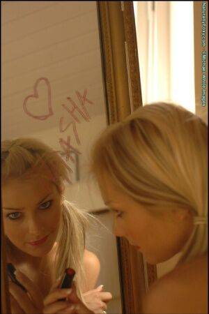 Gorgeous blonde Natasha Marley goes topless in front of a mirror on picsofsex.com