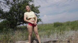 Gorgeous European sits on a log to piss outside on picsofsex.com