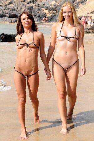 Best friends model revealing bikinis while wondering about a mud flat on picsofsex.com