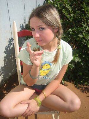 Cute teenage babe Shelby takes a smoke break and flashes us her perky tits on picsofsex.com