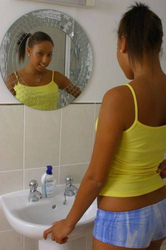 Ponytailed Ebony Teen Amy-Lou Displays Her Shapely Tits While Stripping In The Bathroom on picsofsex.com