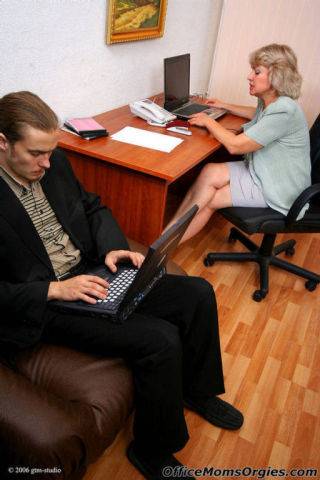 It guy stays in the office and gets seduced by a slutty mature blonde on picsofsex.com