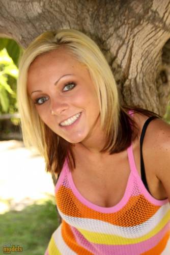 Smiling Blonde Kitty Cali Kayden Shows Her Bald Pussy In The Shadow Of A Tree on picsofsex.com